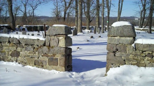 The stone wall around the cemetery where once there was a wrought iron gate